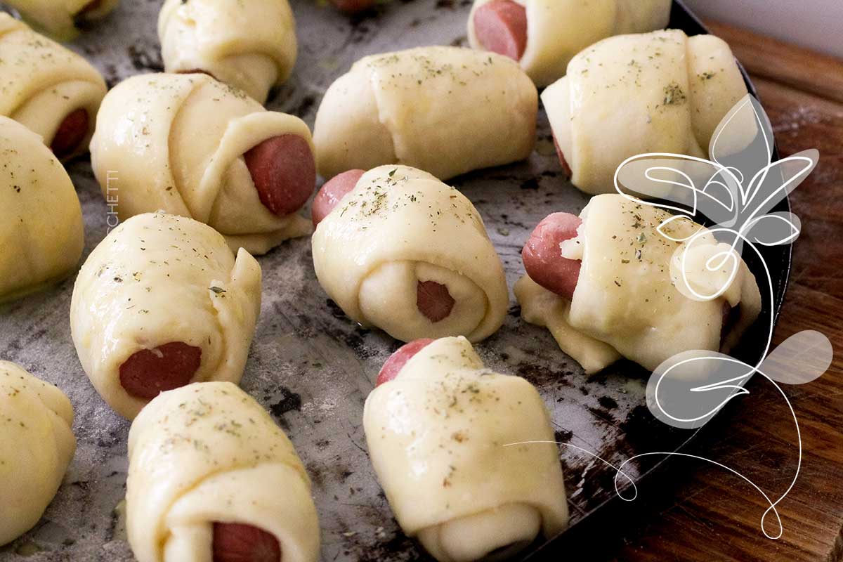 Receita de Cachorrinho Assado - faça um lanche delicioso no final de semana com massa de pão e salsicha assada.